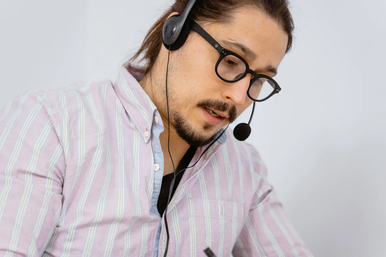 Focused call center agent with headset providing customer support.